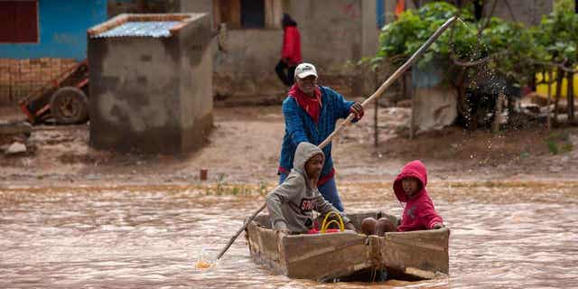 A man steers his boat that is used by residents to move around the flooded street in Antananarivo, Madagascar, on Jan. 28, 2023. Tropical storm Cheneso in Madagascar killed 30 people and left 20 others missing.