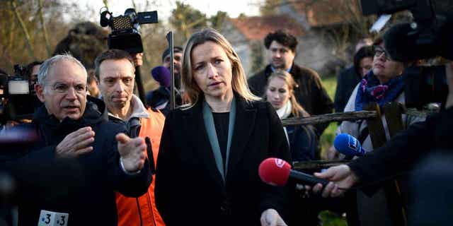 French Secretary of State for Ecology Berangere Couillard holds a tool designed for safety during hunting, in Dry, France, on Jan. 9, 2023. New plans to tighten hunting safety regulations in the country where unveiled on Monday.