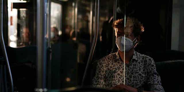 A man wearing a face mask to protect against coronavirus travels in Berlin, Germany, on March 22, 2022. A German doctor has been sentenced to nearly three years in prison for illegally issuing people exemptions from wearing masks during the coronavirus pandemic. 