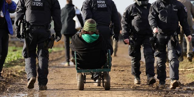 Police carry away activists at the settlement of Luetzerath, Germany, on Jan. 11, 2023.