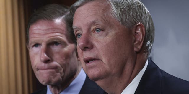 Sen. Richard Blumenthal, D-Conn., listens as Sen. Lindsey Graham speaks during a press conference at the U.S. Capitol May 10, 2022, in Washington, D.C. 