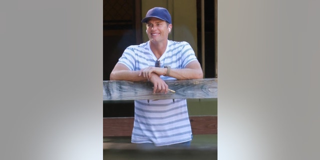Brady was seen smiling proudly while leaning on a fence as he watched Vivian ride a horse around a paddock. 