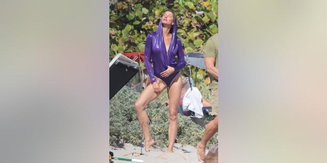 Bündchen's long-sleeved swimsuit featured a hood and a plunging neckline. The Vogue cover star appeared to be back in her element as she chatted with members of the crew during the shoot.
