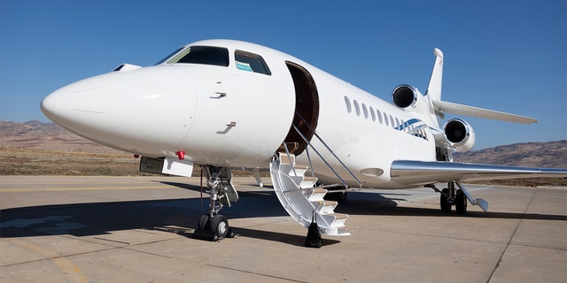 A stock image of a private jet parked on a airport tarmac.