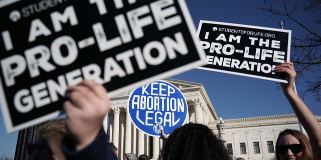 Pro-life activists try to block the sign of a pro-choice activist during the 2018 March for Life Jan. 19, 2018, in Washington, D.C.