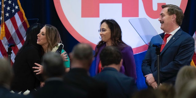 Re-elected Republican National Committee Chair Ronna McDaniel, center, is hugged by a member as candidates Harmeet Dhillon, second from right, and Mike Lindell, right, watch at the committee's winter meeting in Dana Point, Calif., Friday, Jan. 27, 2023. 