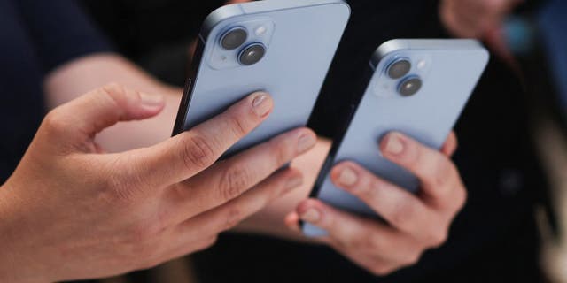 A guest holds the new iPhone 14 at an Apple event at their headquarters in Cupertino, California, Sept. 7, 2022.