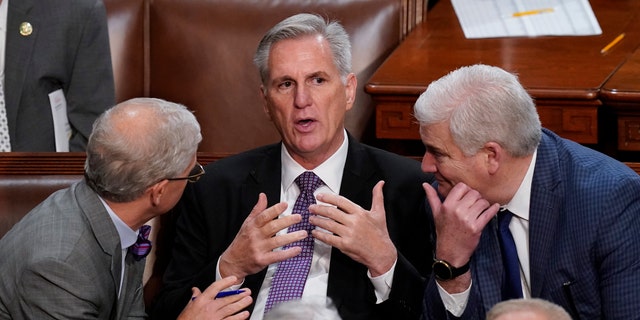 Rep. Patrick McHenry, R-N.C., left, and Rep. Tom Emmer, R-Minn., right, speak with Rep. Kevin McCarthy, R-Calif., in the House chamber as the House meets for a second day to elect a speaker and convene the 118th Congress in Washington, Wednesday, Jan. 4, 2023. 
