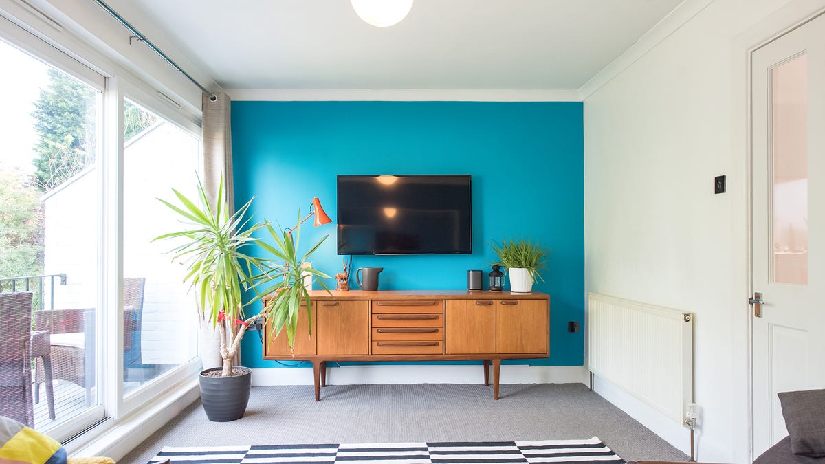 A well-lit and modern room with reflections on the TV