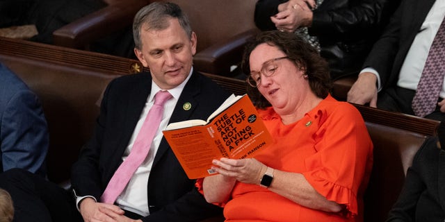 Rep. Katie Porter, D-Calif., shows her book to Rep. Sean Casten, D-Ill., during the 15th vote to elect a Speaker of the House early Saturday morning, Jan. 7, 2023.