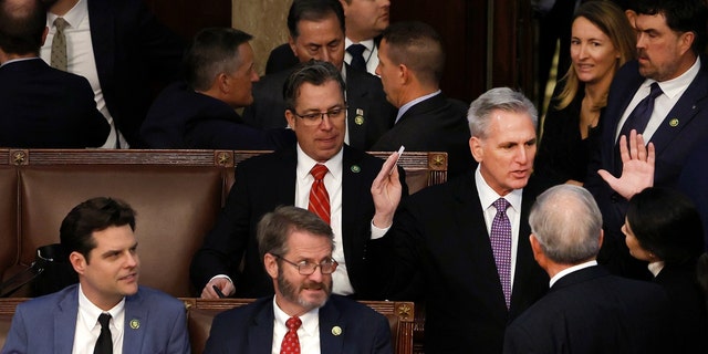 House Republican Leader Kevin McCarthy talks members-elect as Rep.-elect Matt Gaetz, R-Flo., and Rep.-elect Tim Burchett, R-Tenn. watch in the House Chamber during elections for Speaker.