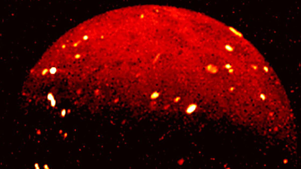 Infrared view of Jupiter moon Io shows it partly in red with lots of bright spots indicating higher temperatures.
