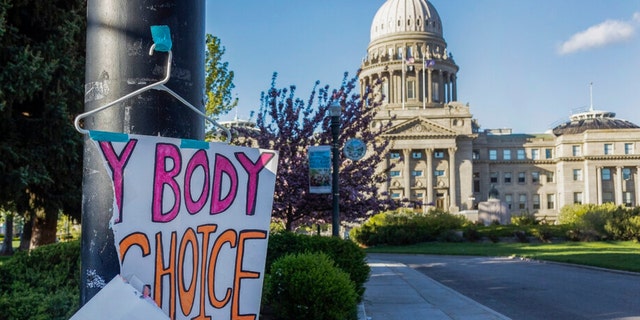FILE - A sign reading "My body, my Choice," is taped to a hanger taped to a streetlight in front of the Idaho State Capitol Building on May 3, 2022. The Idaho Supreme Court ruled on Friday, Aug. 12, that the state's strict abortion bans will be allowed to take effect while legal challenges over the laws play out in court. 