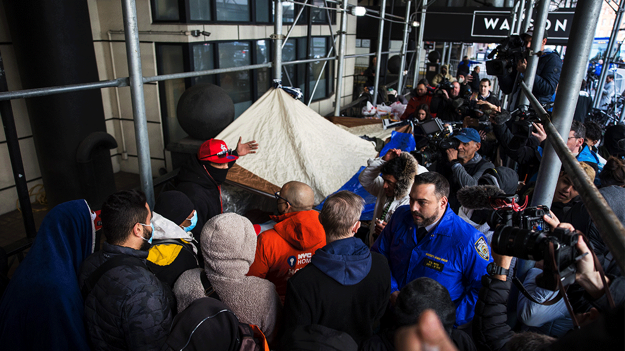 Migrants speak with NYC homeless outreach members as they camp out in front of the Watson Hotel after being evicted on Jan. 30, 2023.