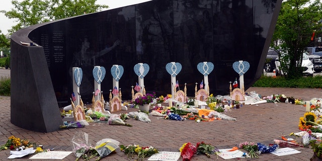 People lay flowers and cards near a spot where a mass shooting took place during the 4th of July parade in Highland Park, Illinois.