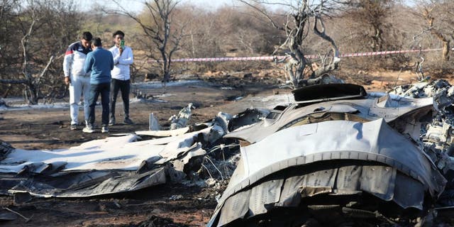 People stand next to a plane wreckage after a Sukhoi Su-30 and a Dassault Mirage 2000 fighter jets crashed during an exercise in Pahadgarh area some 30 miles from Gwailor on Jan. 28, 2023.