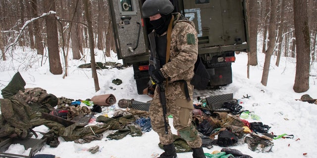 A volunteer with the Ukrainian Territorial Defense Forces inspects a damaged military vehicle in the outskirts Kharkiv, Ukraine's second-largest city, on March 7, 2022.