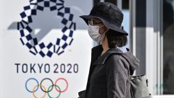 A woman walks past a Tokyo 2020 poster during a test of potential spectator and games screening measures ahead of the Tokyo 2020 Olympic Games, now postponed until July 2021 due to the COVID-19 coronavirus pandemic, in Tokyo on October 21, 2020. (Photo by Charly TRIBALLEAU / AFP) / TO GO WITH OLYMPICS PACKAGE (Photo by CHARLY TRIBALLEAU/AFP via Getty Images)