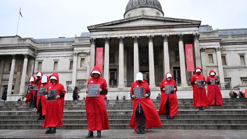 Protesters wearing 'Handmaid's Tale' costumes hold placards as they hold a silent march through central London on January 7 to raise awareness about the recent women-led uprising in Iran. 