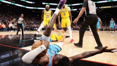 Deandre Ayton of the Phoenix Suns falls over Austin Reaves of the Los Angles Lakers after being pushed by Patrick Beverley during the second half of the game at Footprint Center in Phoenix, Arizona. 