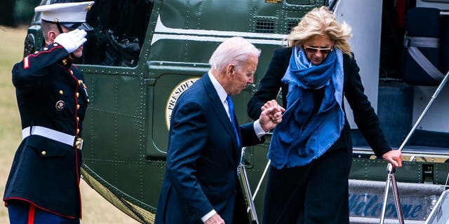 US President Joe Biden helps First Lady Dr. Jill Biden exit Marine One on the South Lawn of the White House on Monday January 23, 2023.