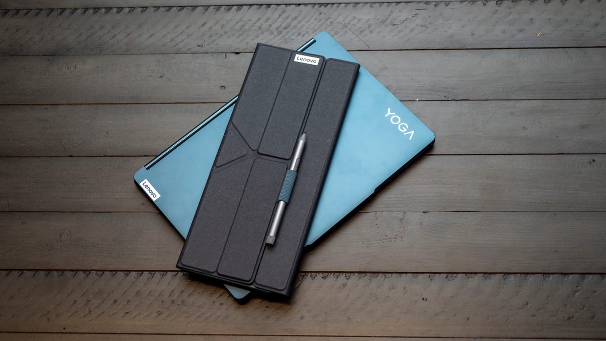 Lenovo Yoga Book 9i dual-screen laptop closed with its keyboard and pen wrapped up for travel in the laptop's folding stand.
