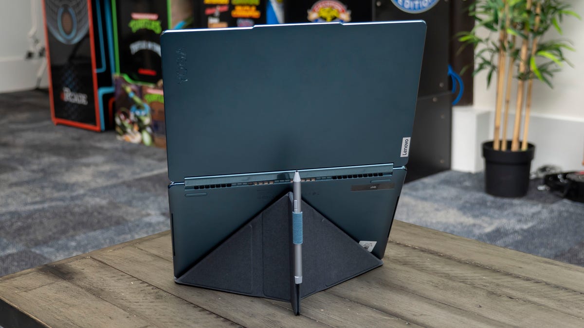 A look at the rear of the Yoga Book 9i on its folding stand with its included active pen in its holder.