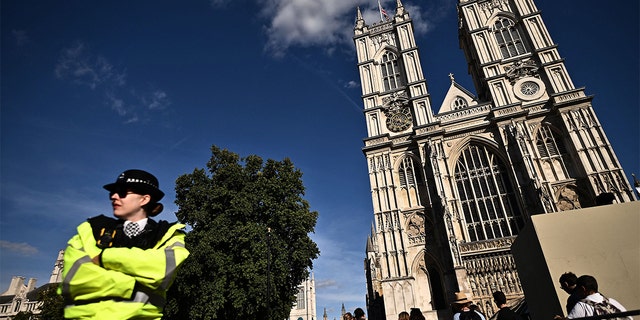 A member of the London Met Police stands guard outside Westminster Abbey. 
