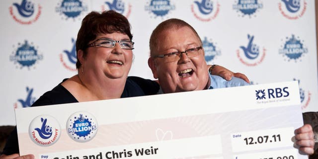 Colin Weir and his wife Chris pose during a photocall in Falkirk, Scotland, on July 15, 2011, after winning a record EuroMillions jackpot on July 15, 2011.