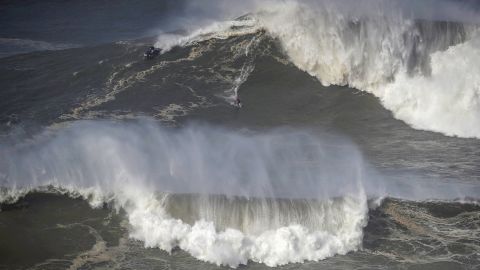 A surfer rides a wave in Praia do Norte, Nazaré, Portugal, February 25, 2022.