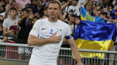 Andriy Shevchenko poses next to the Ukainian flag after an exhibition football match on May 23, 2022.