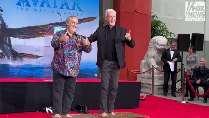 'Avatar' director James Cameron and producer Jon Landau dip their feet in wet cement for Hollywood ceremony