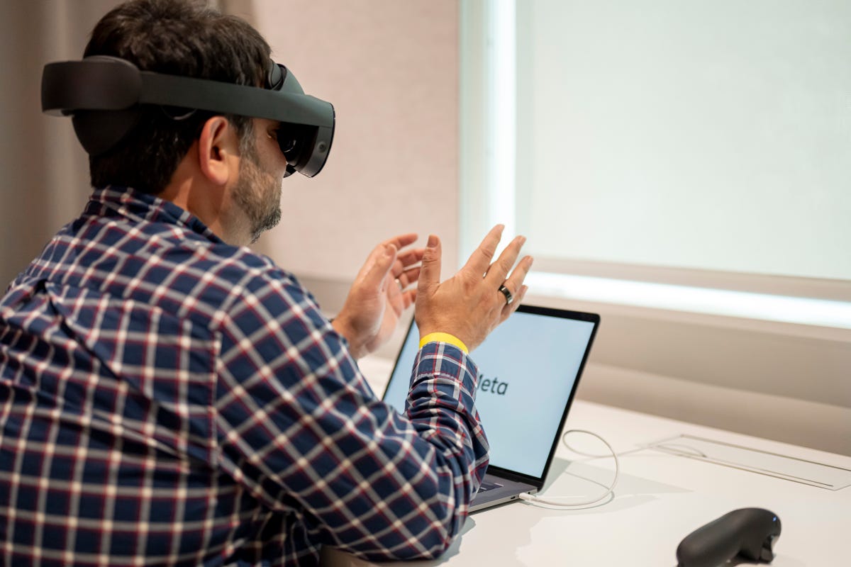 Quest Pro VR headset, being worn while sitting at a desk