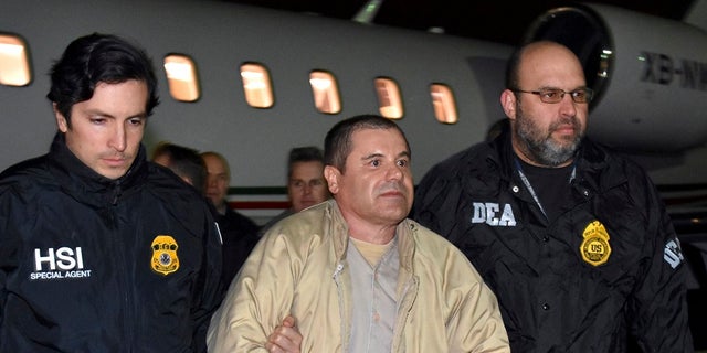 Authorities escort Mexican drug lord Joaquin "El Chapo" Guzman, center, from a plane in Ronkonkoma, N.Y.  