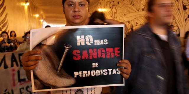 A man carrying a sign saying "No more blood of journalists" during a protest to demand justice in the Regina Martinez case
