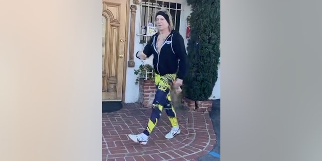 Mickey Rourke was dressed in an unzipped black hoodie that displayed his tattooed chest while wearing neon yellow and black workout pants. He sported white sneakers and a black headband.