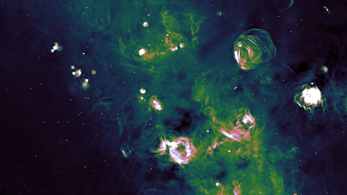 Radio observation of a portion of the Milk Way with diffuse stretch of green and bubbles of gas representing supernova remnants.