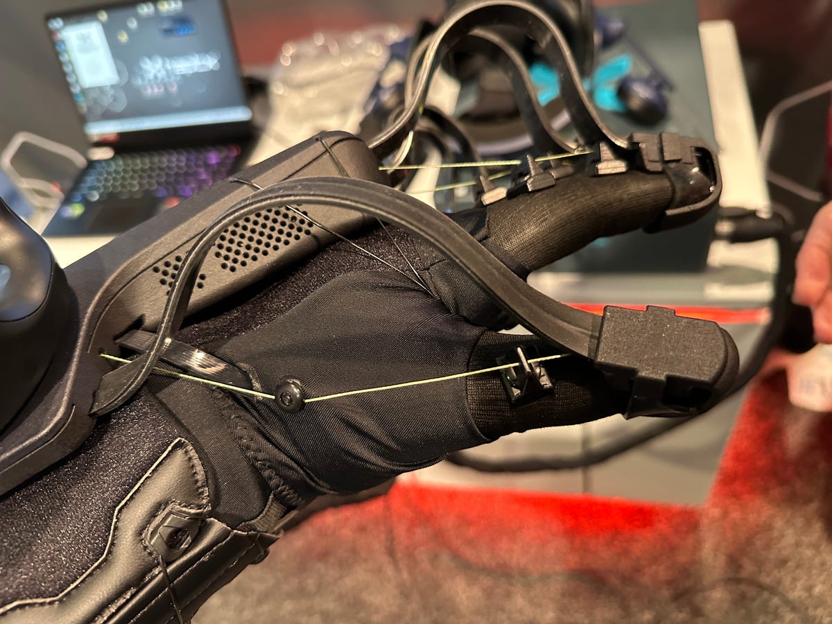 A hand covered in a cable-covered haptic glove.