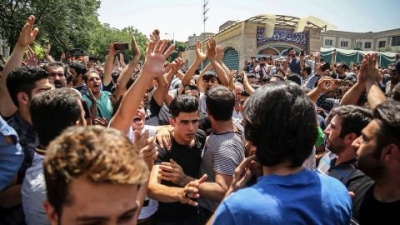 In this June 2018 photo, a group of protesters chant slogans at the main gate of the Old Grand Bazaar, in Tehran, Iran. The case of 27-year-old Navid Afkari has drawn the attention of a social media campaign that portrays him and his brothers as victims targeted over participating in protests against Iran's Shiite theocracy in 2018. 
