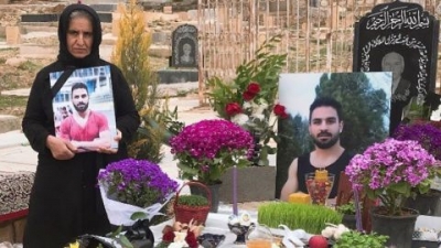 Navid's mother (left) stands by Navid's grave in March 2021 in Shiraz, Iran. 