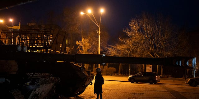 A woman stands in front of a display of destroyed Russian tanks and armored vehicles in downtown Kyiv, Ukraine, Friday, Jan. 20, 2023. (AP Photo/Daniel Cole)