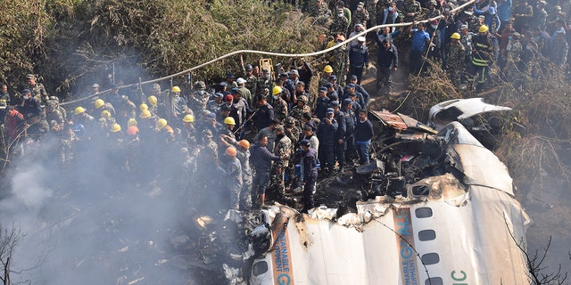 Nepalese rescue workers and civilians gather around the wreckage of a passenger plane that crashed in Pokhara, Nepal, Sunday, Jan. 15, 2023. Authorities in Nepal said 68 people have been confirmed dead after a regional passenger plane with 72 aboard crashed into a gorge while landing at a newly opened airport in the resort town of Pokhara. It's the country's deadliest airplane accident in three decades.