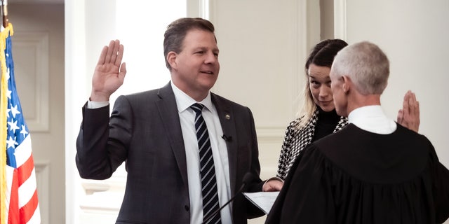 New Hampshire Gov. Christopher T. Sununu is sworn in to serve his fourth term by state Supreme Court Chief Justice Gordon J. MacDonald at Representative Hall at the State House Thursday, Jan. 5, 2023, in Concord, N.H. First lady Valerie Sununu, center, listens. 