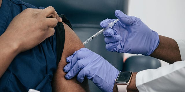 Lenox Hill Hospital Chair of Emergency Medicine Yves Duroseau receives the COVID-19 vaccine from Doctor Michelle Chester at Long Island Jewish Medical Center.