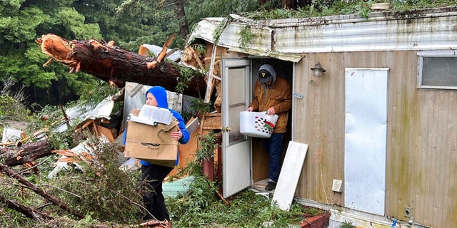 Family friends remove items from the mobile home where 2-year-old Aeon Tocchini was killed by a fallen redwood tree in Occidental, Calif., on Jan. 5, 2023. 