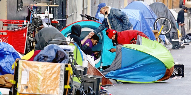 Homeless people consume illegal drugs in an encampment along Willow Street in the Tenderloin district of San Francisco on Feb. 24, 2022.