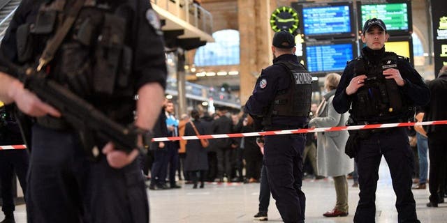 French police stand guard in a cordonned off area at Paris' Gare du Nord train station, after several people were lightly wounded by a man wielding a knife on Jan. 11, 2023.