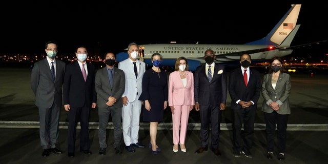 In this photo released by the Taiwan Ministry of Foreign Affairs, U.S. House Speaker Nancy Pelosi, center pose for photos after she arrives in Taipei, Taiwan, Tuesday, Aug. 2, 2022. Pelosi arrived in Taiwan on Tuesday night despite threats from Beijing of serious consequences, becoming the highest-ranking American official to visit the self-ruled island claimed by China in 25 years.