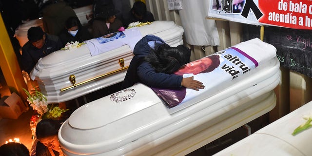 A woman cries over a coffin containing the remains of her friend Antonio Samillan who died during the unrest in Juliaca, Peru, Tuesday, Jan. 10, 2023. 