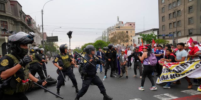 Anti-government protesters who traveled to the capital from across the country to march against Peruvian President Dina Boluarte clash with the police in Lima, Peru, Wednesday, Jan. 18, 2023. Protesters are seeking immediate elections, Boluarte's resignation, the release of ousted President Pedro Castillo and justice for the dozens of protesters killed in clashes with police. 